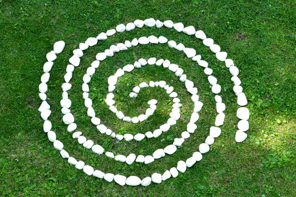 double spiral make with white rocks places on green grass